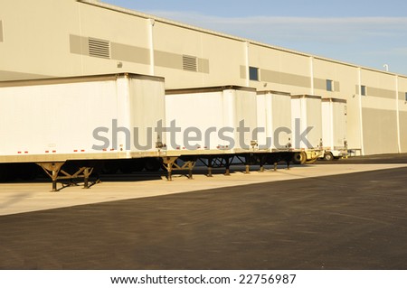 many trucks lined up at an industrial warehouse