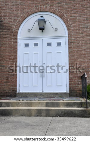 double white entry doors for a red brick church