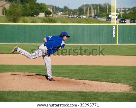 action shot of a high school baseball pitcher winding up to throw the baseball