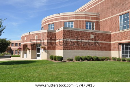 exterior of a modern brick high school by a lush green lawn