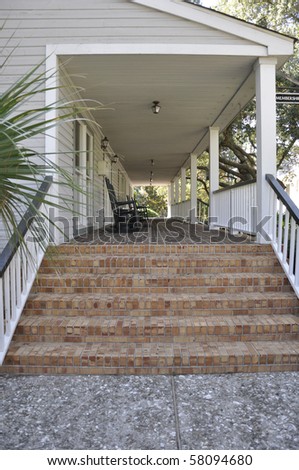 Many red brick steps leading to a covered porch.