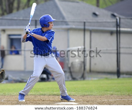 teenage baseball player in the batter\'s box