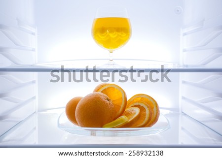Refrigerator,  modern stylish design. Interior, inside  image, glass shelf, oranges, cocktail, jelly bean, clean, light, web banner