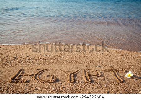 Wallpaper, the Red  Sea holidays background. Inscription Egypt and exotic flower on the sand