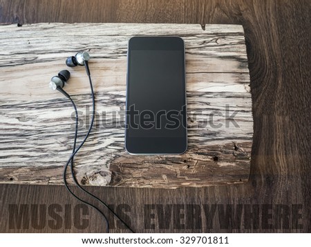 Music player with headphones on a piece of wood. Music is everywhere