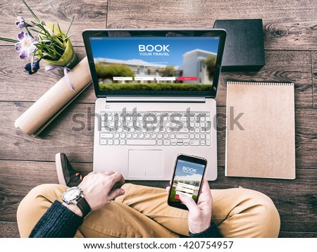 Man using a laptop and smartphone for booking hotel online. Tour reservation, Screen graphics are made up.
