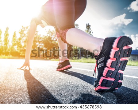 Young Girl Runner feet on track closeup focus on sport shoe. Getting ready to start