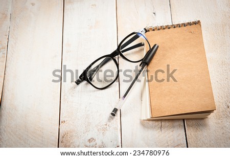 notepad,glasses and ink pen on the wooden
