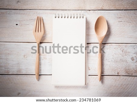 blank recipe book with wooden spoon, vintage toned