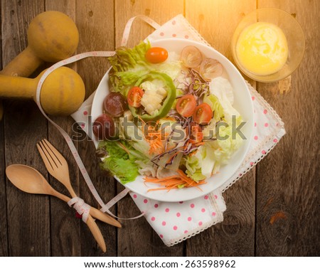 Dumbells, tape measure and healthy food salad on wooden background,View from above