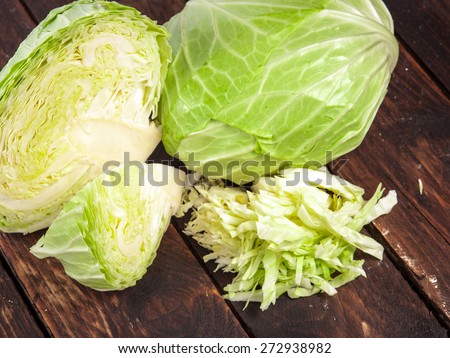 cabbage and cutted cabbage on old wooden desk