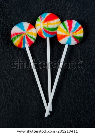 Colorful spiral lollipop lolly pop on black leather