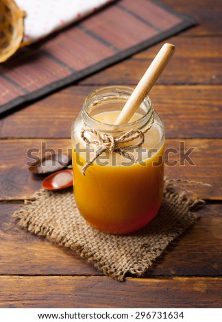 Honey drip in jar on the table
