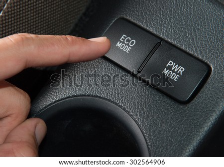 Hand finger press button Eco mode in car,Green concept.