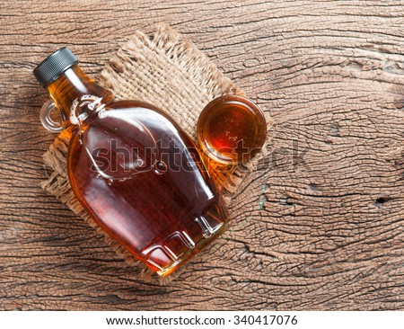 maple syrup in glass bottle on wooden table