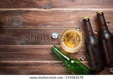 Beer glass with bottle cap and bottle on rustic wood background,space for text,top view