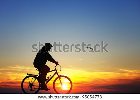 Silhouette of a man on bike at sunset