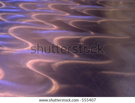 Waves brushed into the surface of a stainless steel surface.