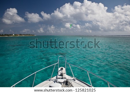 The bow of a dive boat heads out through clear, shallow water towards a dive site in Grand Cayman.  This island in the Caribbean is known for its excellent scuba diving.