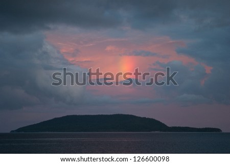 A late afternoon rainbow appears above an island in Raja Ampat, Indonesia.  This area is extremely diverse in terms of its marine life.