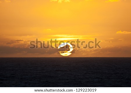 The sun rises over the tropical South Pacific Ocean in French Polynesia.