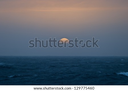 Low on the horizon, the sun shows as a beautiful ball of color.  Antarctica has some of the most beautiful sunrises and sunsets on Earth.