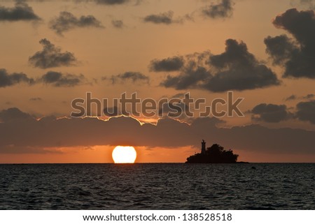 The sun drops below the horizon as seen from the harbor of Sorong, Papua, Indonesia.  This region is possibly the most diverse area in the world for marine life.