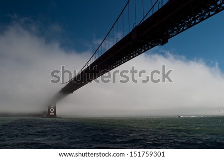 As fog drifts in from the Pacific Ocean to cover San Francisco the Golden Gate bridge slowly disappears.  The bridge is one of the city\'s most iconic sites.