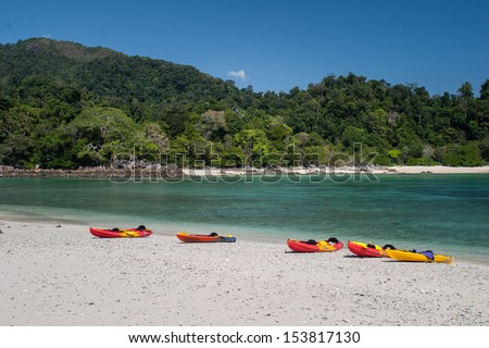 Kayaks are pulled up on a white sand beach on a remote island in the Mergui Archipelago, Myanmar. This group of tropical islands in the Andaman Sea is rarely visited yet are extremely beautiful.