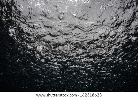 Rain drops fall on the surface of the water near the equator in the western Pacific Ocean.