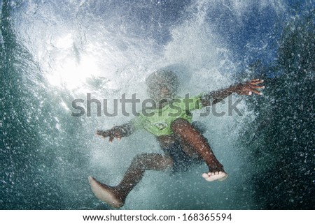 A young Solomon Island boy jumps into the sea. Villagers live close to the sea in this area and depend on the environment for natural resources.