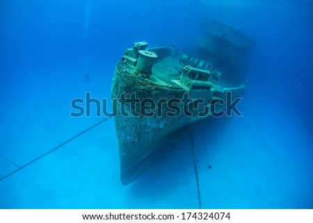 A massive shipwreck, the Kittewake, sits on a sandy seafloor in Grand Cayman. This ship was sunk intentionally to act as an artificial reef and as an attraction for scuba divers.