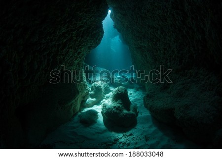 Sunlight penetrates the sea and illuminates a dark crevice at a dive site known as Yap Caverns. Dark niches such as this provide habitat to many shade-loving marine species.