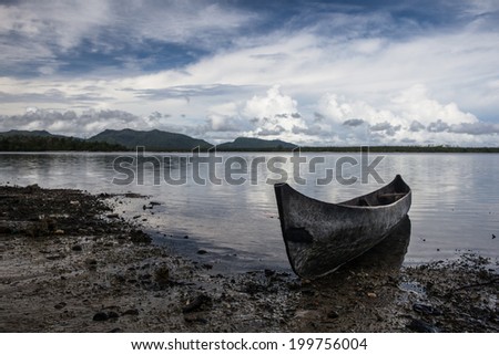 A dugout canoe lays on a remote beach in the Solomon Islands. Islanders throughout the Solomons still use canoes and outriggers as their main form of transportation.