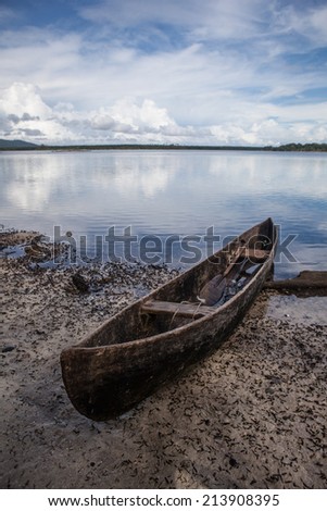 A dugout canoe, owned by a local fisherman, has been pulled up onto a remote beach in the Solomon Islands. Many islanders continue to use dugout canoes as their main form of transportation.