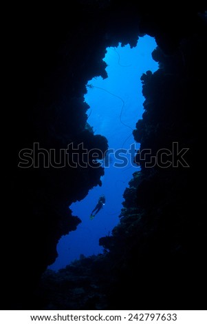 A scuba diver explores the mouth of an underwater cave off the Caribbean island of Grand Cayman. The Caymans are a popular vacation destination for divers, snorkelers, and beach lovers.