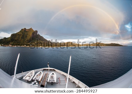 A full rainbow appears over the idyllic tropical island of Bora Bora in French Polynesia. Rainbows often form in the tropics after rain showers.
