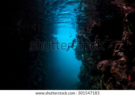 A snorkeler explores a dark grotto in the Solomon Islands. Coral reefs in this Melanesian region are exceedingly diverse in terms of habitats. The area also offers great scuba diving and snorkeling.