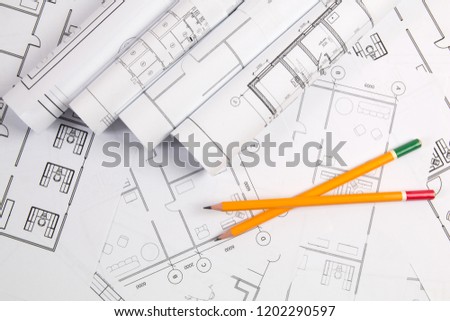Pencils and paper engineering house drawings and blueprints.