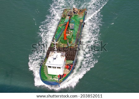 Aerial side view of cargo ship on open sea
