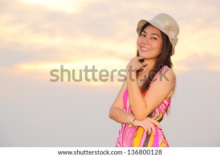Beautiful woman in pink dress and sunshine twilight background
