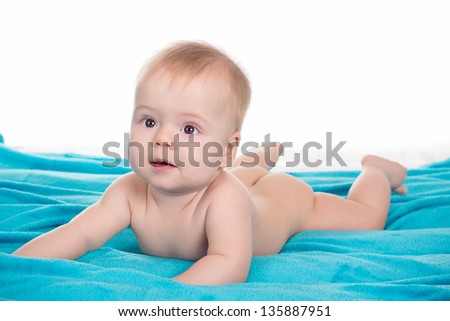 Joyful naked baby is creeping on all fours