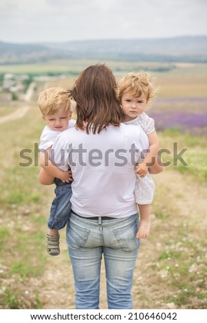 mother and two children cry in a field