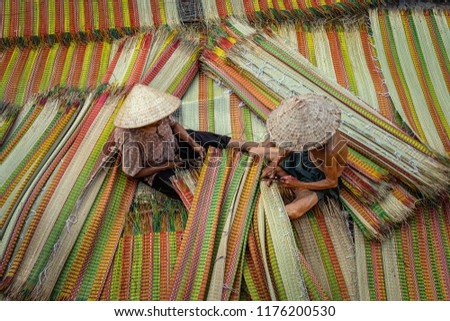 Top view of old Vietnamese lover craftsman making the traditional vietnam mats in the old traditional village at dinh yen, dong thap, vietnam, tradition artist concept