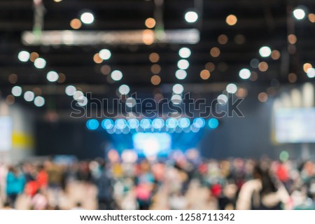 Abstract blurred photo of conference hall or seminar room in Exhibition Center with speakers on the stage and attendee background, seminar and study concept