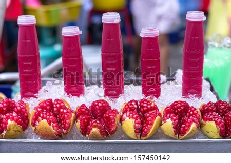 Ripe pomegranate fruit and water in bottle