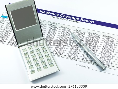 insurance coverage report with calculator and pen for business