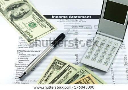 income statement report with calculator, pen and usd money for business