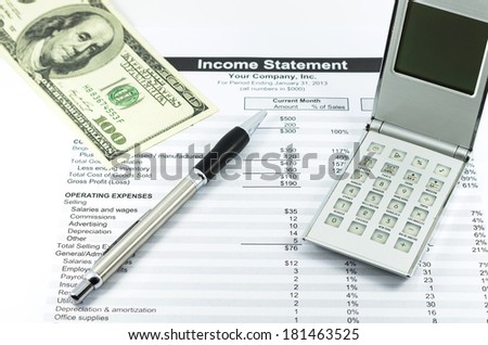 income statement report with calculator, pen and usd money for business