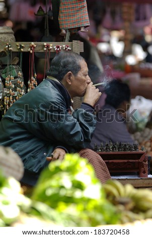 BAGAN, MYANMAR- JAN 4: An unidentified Bumese man smoking a cheroot cigar in market at bagan,Myanmar on January 4, 2011. A cheroot is a cigar made principally by dried fruits and little bit of tobacco